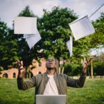 excited african american male student celebrating successful results of exams